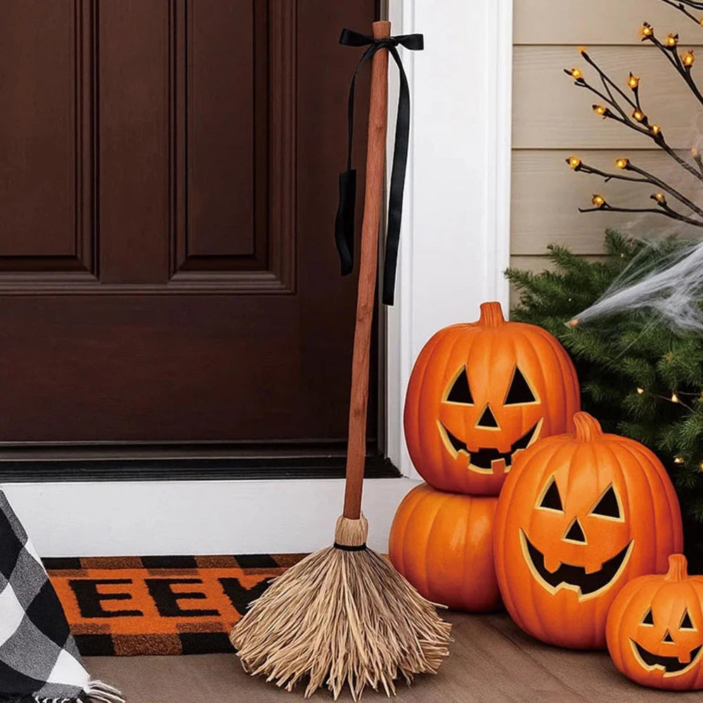 Dancing witch's broom by a front door with jack-o'-lanterns