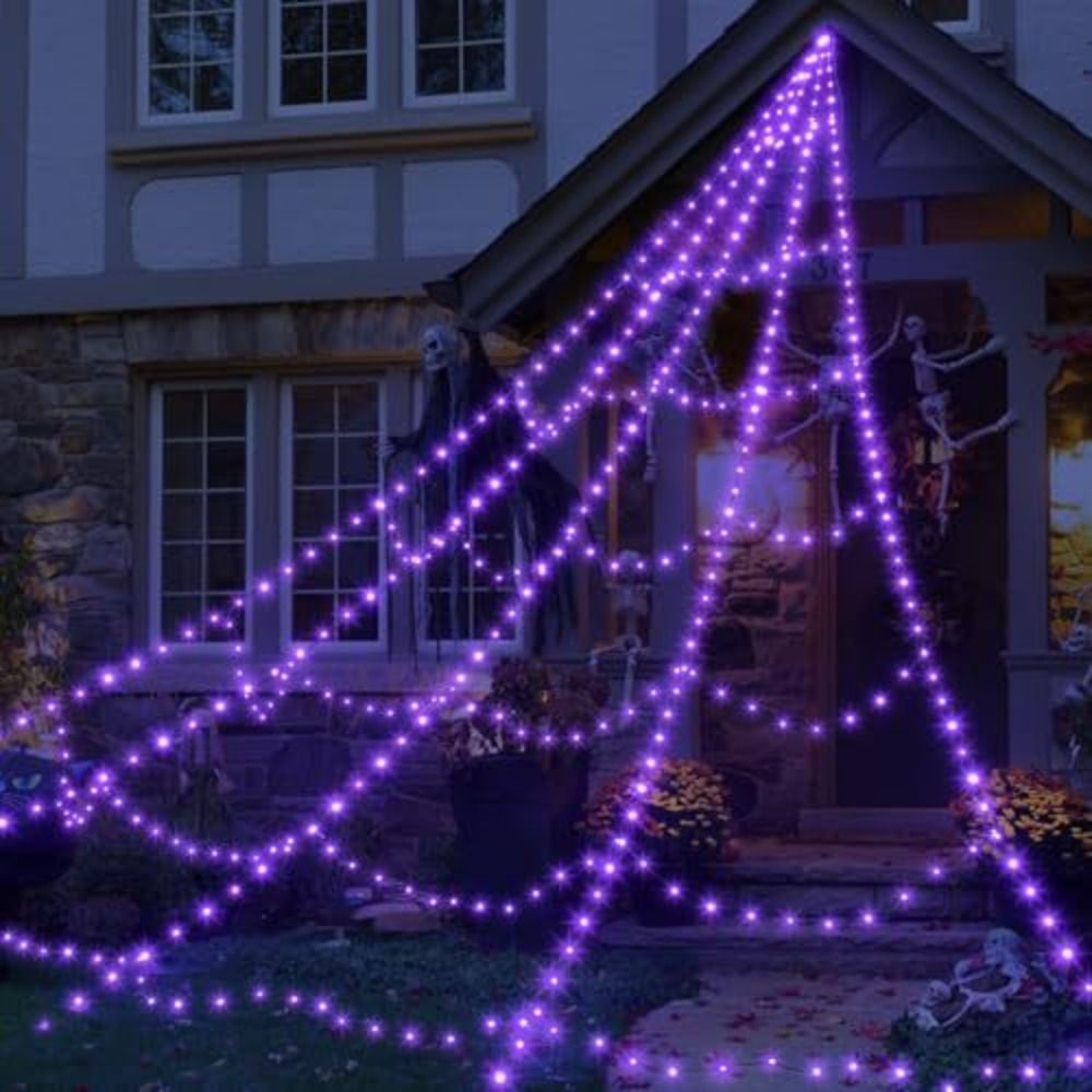 Giant purple LED spider web lighting up the front of a house