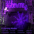 Purple LED spider web lights glowing on a haunted house at night