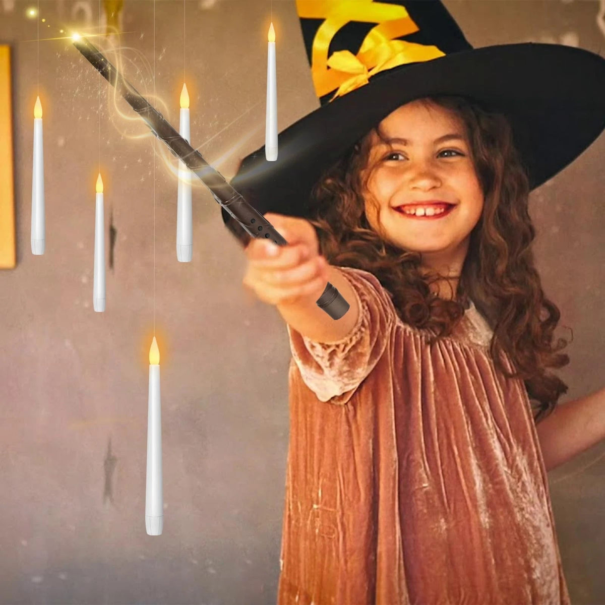 Girl in a witch hat waving the wand under floating candles